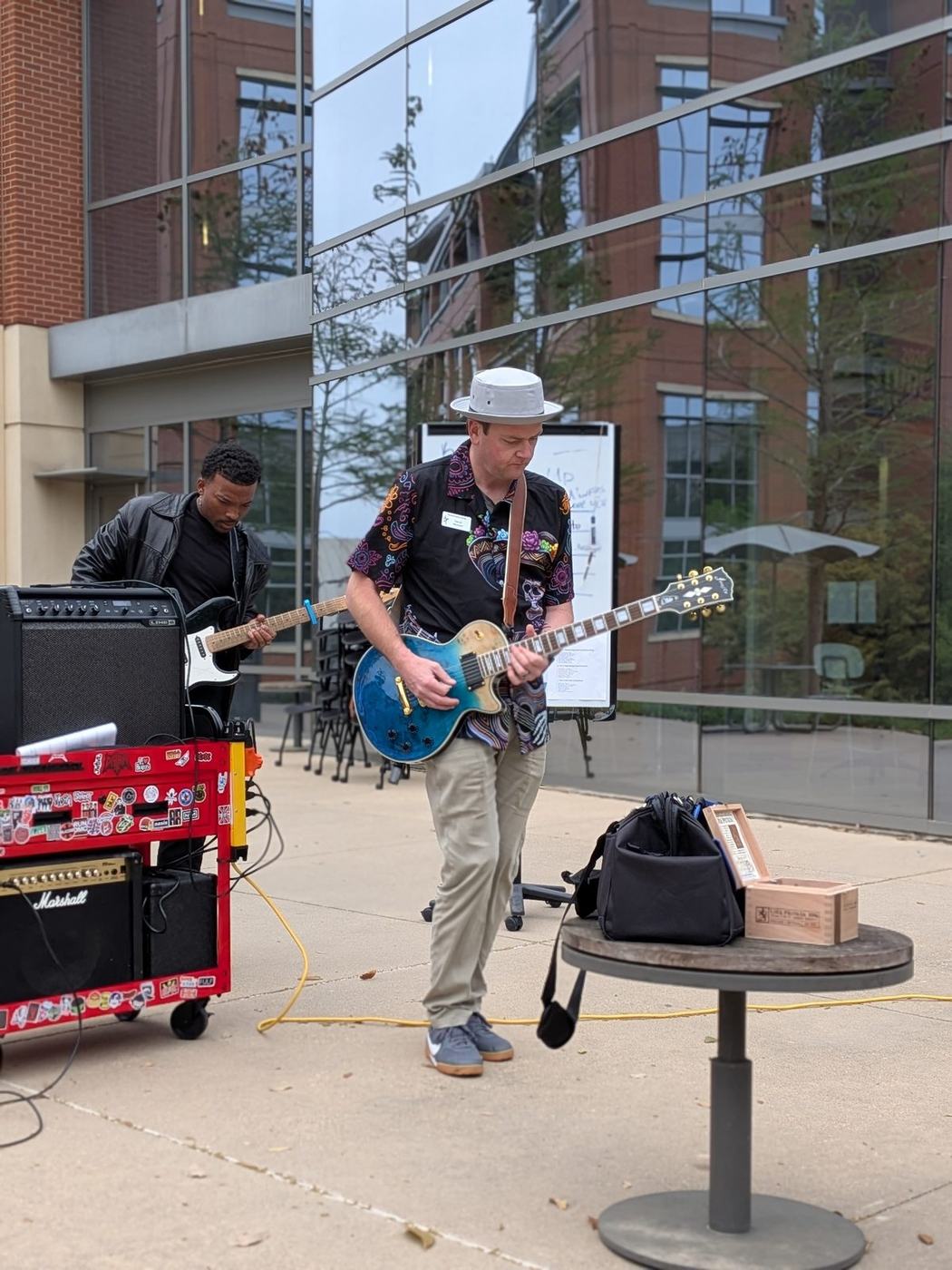 A club member playing an electric guitar through a Marshall amp on the plaza